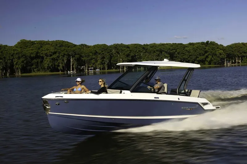 The Image of A modern motorboat speeds across a calm lake, surrounded by lush trees. - 0