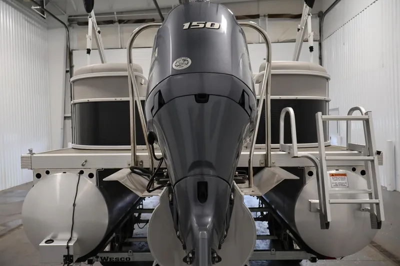 Slide: The Image of 2023 Bennington SV 22 Quad Bench pontoon boat with powerful outboard motor in a storage facility. - 6