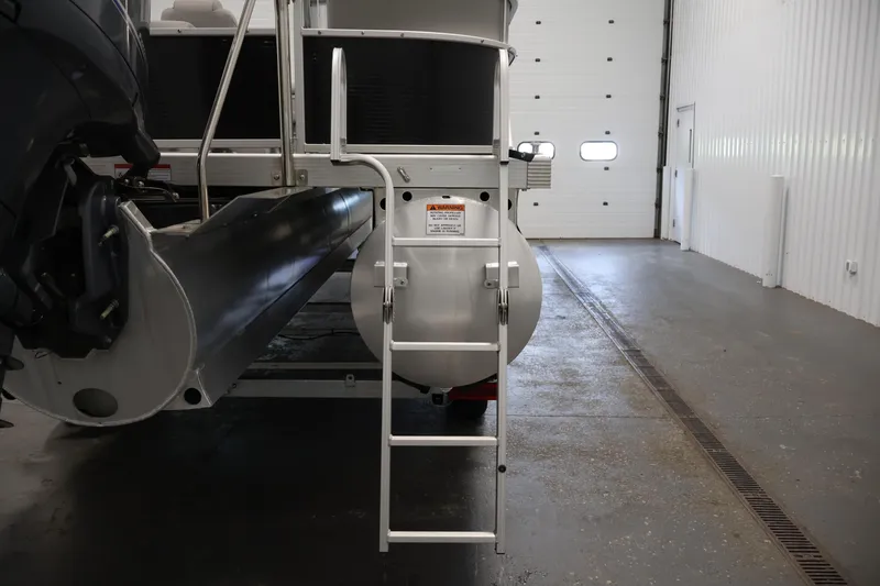Slide: The Image of 2023 Bennington SV 22 Quad Bench pontoon boat rear view with ladder in a garage. - 34