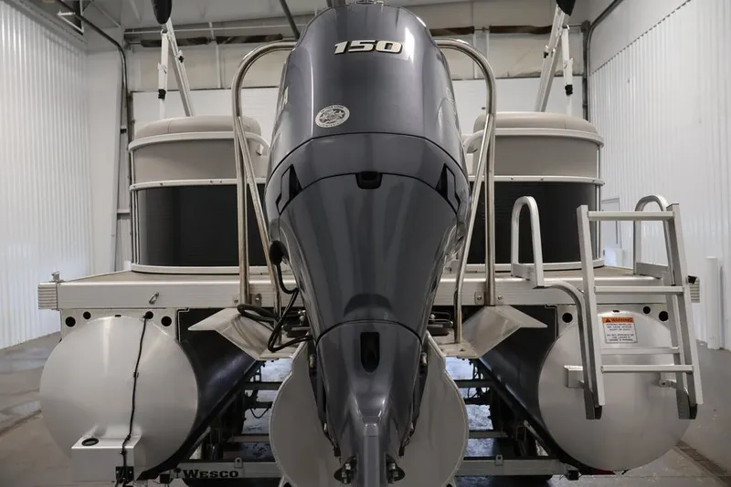Slide: The Image of 2023 Bennington SV 22 Quad Bench pontoon boat with powerful outboard motor in a storage facility. - 7