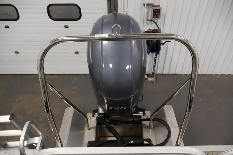 Slide: The Image of 2023 Bennington SV 22 Quad Bench with powerful outboard motor in a garage setting. - 33