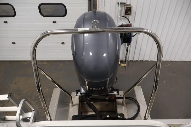 Slide: The Image of 2023 Bennington SV 22 Quad Bench with 150 HP outboard motor in a garage setting. - 42