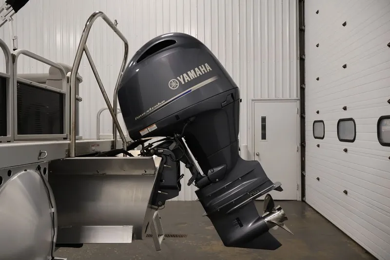 Slide: The Image of 2023 Bennington SV 22 Quad Bench with Yamaha outboard motor in a garage. - 32