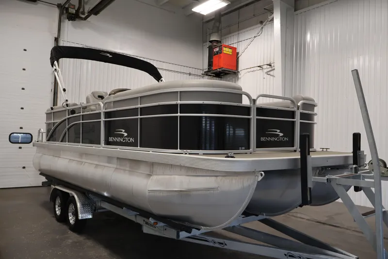 Slide: The Image of 2023 Bennington SV 22 Quad Bench pontoon boat on trailer in indoor storage. - 3