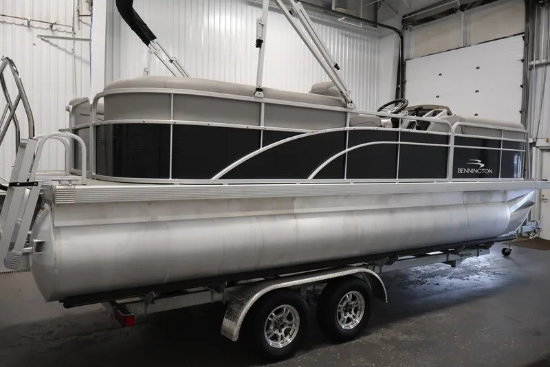 Slide: The Image of 2023 Bennington SV 22 Quad Bench pontoon boat on trailer in indoor storage. - 5