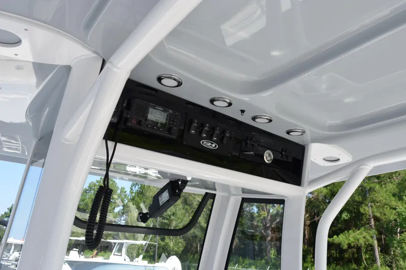 Slide: The Image of 2026 Sea Hunt Ultra 245 SE boat console with electronic controls and overhead storage. - 12