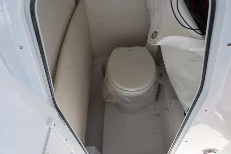 Slide: The Image of Interior of 2026 Sea Hunt Ultra 245 SE boat with compact marine toilet. - 15
