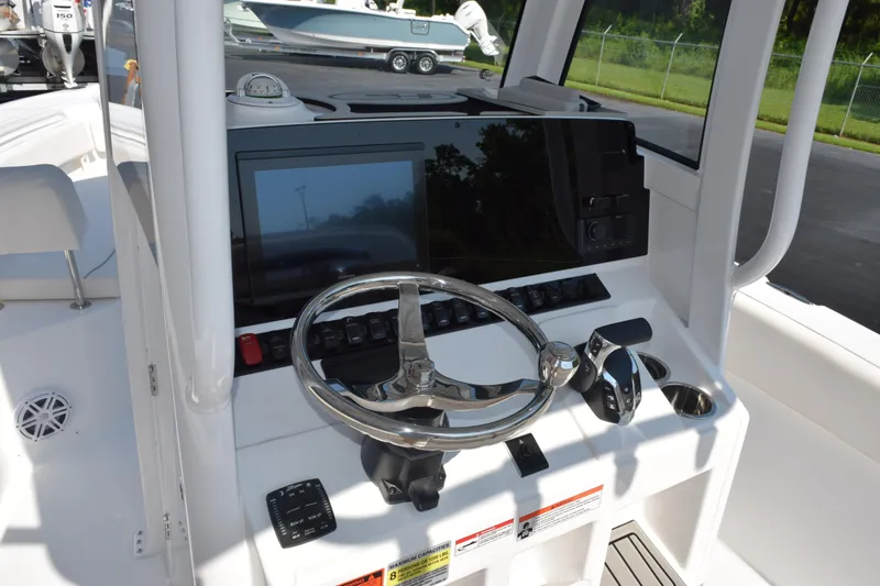 Slide: The Image of 2026 Sea Hunt Ultra 245 SE boat helm with steering wheel and control panel. - 11