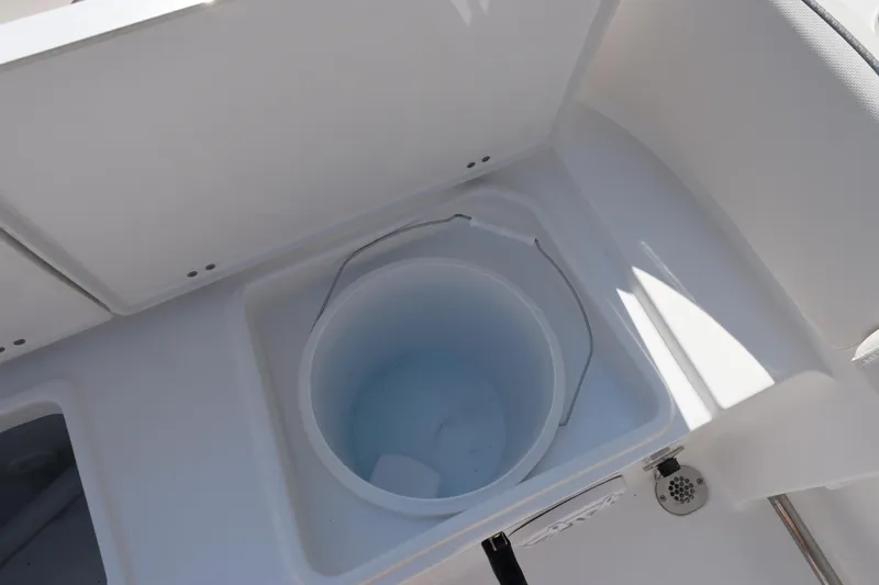 Slide: The Image of Livewell on 2026 Sea Hunt Ultra 245 SE boat, featuring a white bucket and drain. - 24