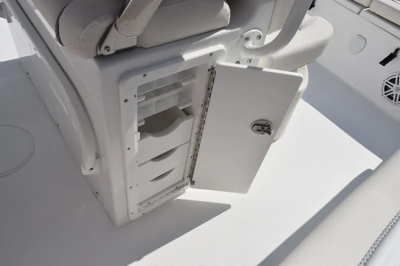 Slide: The Image of Storage compartment on 2026 Sea Hunt Ultra 245 SE boat, featuring open door and drawers. - 19