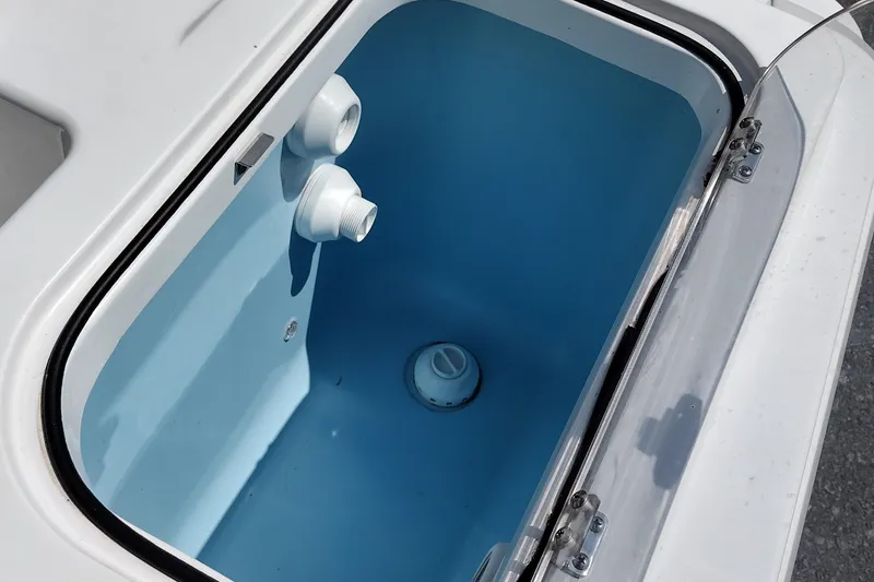 Slide: The Image of Livewell compartment in 2024 Wellcraft 223 Fisherman boat, featuring blue interior and drainage system. - 25