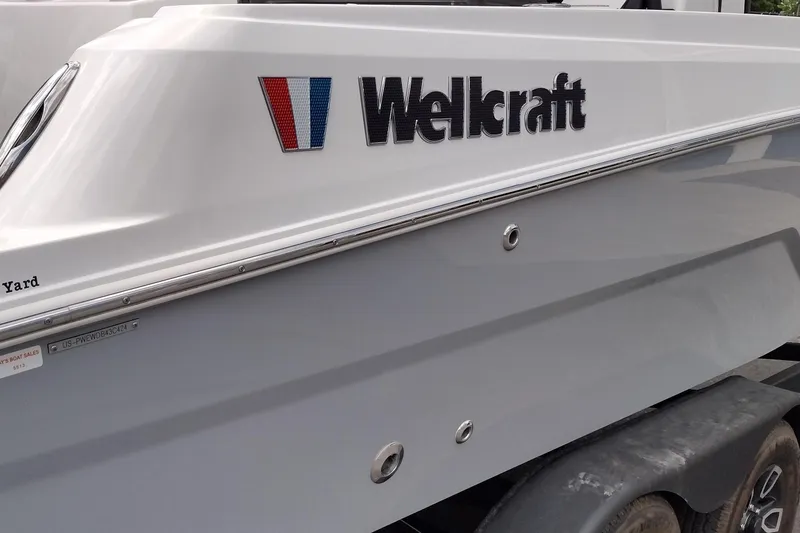 Slide: The Image of 2024 Wellcraft 223 Fisherman boat side view with logo and sleek design. - 9