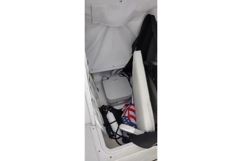 Slide: The Image of 2024 Wellcraft 223 Fisherman storage area with equipment and American flag. - 18