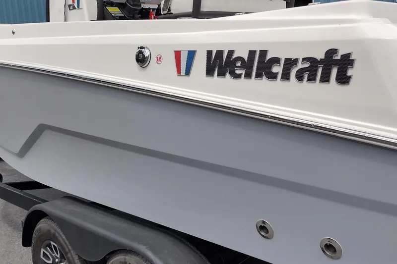 Slide: The Image of 2024 Wellcraft 223 Fisherman boat side view with logo, on a trailer. - 10
