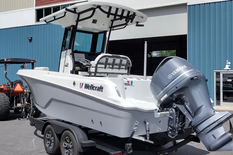 Slide: The Image of 2024 Wellcraft 223 Fisherman boat with Yamaha engine on trailer, parked outside a building. - 6