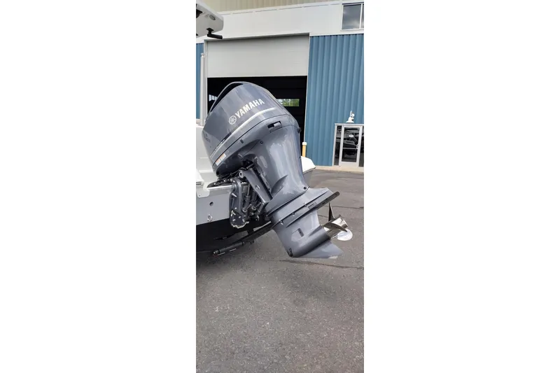 Slide: The Image of 2024 Wellcraft 223 Fisherman with Yamaha outboard motor, parked outside a blue building. - 8