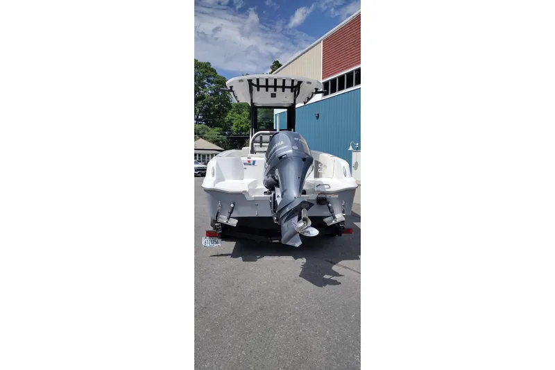Slide: The Image of 2024 Wellcraft 223 Fisherman boat with outboard motor, parked outdoors. - 7