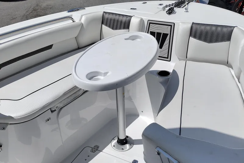 Slide: The Image of 2024 Wellcraft 223 Fisherman boat interior with seating and table setup. - 19