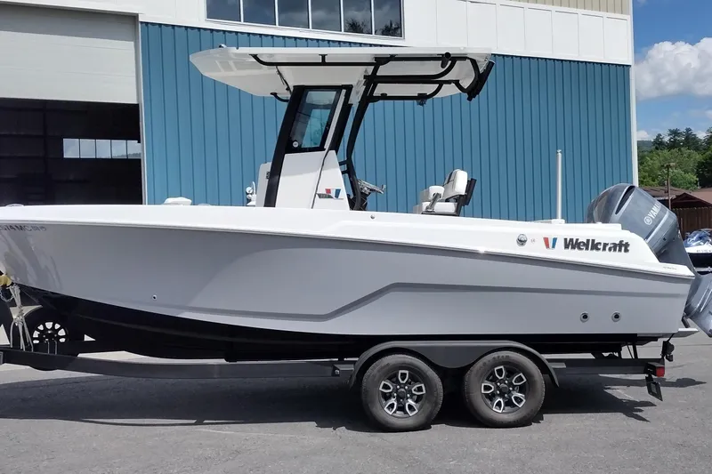 The Image of 2024 Wellcraft 223 Fisherman boat on trailer, parked outside a blue building. - 1