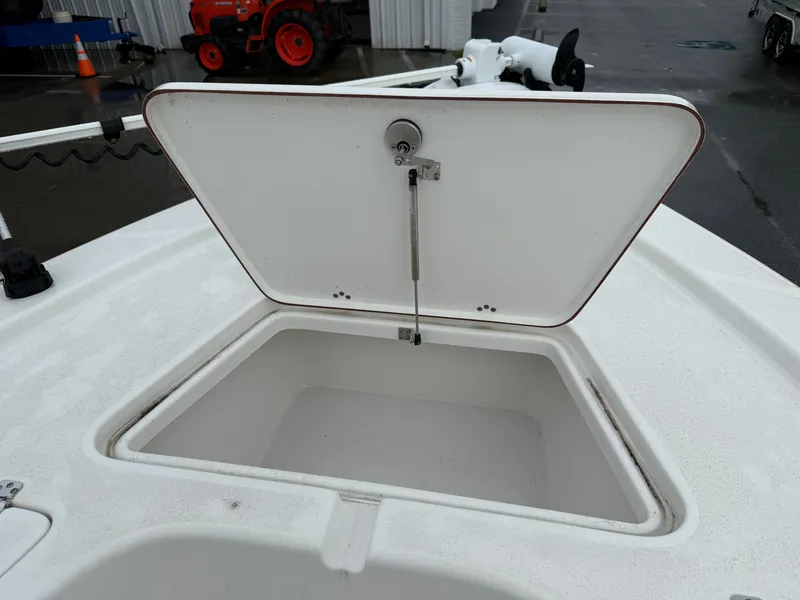 Slide: The Image of An open storage compartment on a boat with a white lid. - 13