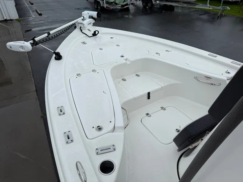 Slide: The Image of The image shows the deck of a 2025 Sea Pro 230 DLX boat with storage and fishing rod holders. - 8