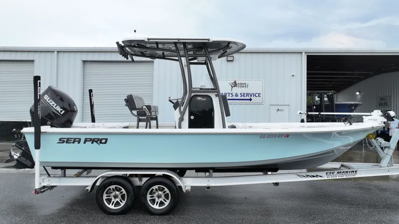 The Image of Sea Pro 230 DLX 2025 on a trailer in front of a workshop. - 0