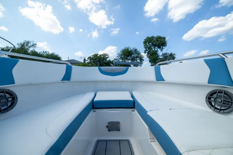 Slide: The Image of Interior view of 2026 Chaparral 250 OSX boat with blue and white seating under a clear sky. - 6