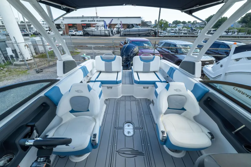 Slide: The Image of 2026 Chaparral 250 OSX boat interior with modern seating and sleek design at marina. - 8