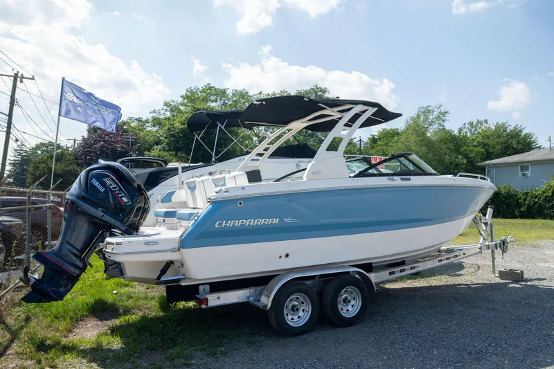 The Image of 2026 Chaparral 250 OSX boat on trailer, featuring Yamaha outboard motor, parked outdoors. - 1