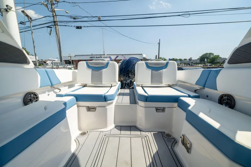Slide: The Image of 2026 Chaparral 250 OSX boat interior with blue and white seating, docked at marina. - 14