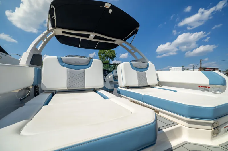Slide: The Image of 2026 Chaparral 250 OSX boat interior with blue and white seating under a sunny sky. - 19