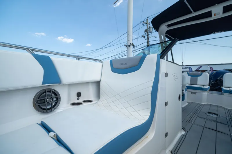 Slide: The Image of 2026 Chaparral 250 OSX boat interior with blue and white seating, speaker, and cup holders. - 7