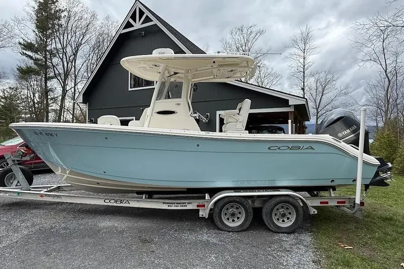 Slide: The Image of 2020 Cobia 240 Center Console boat on trailer, parked near a house. - 15