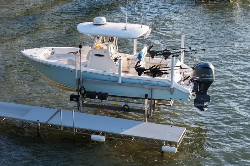 Slide: The Image of 2020 Cobia 240 Center Console boat on lift, equipped with Yamaha outboard motor. - 5