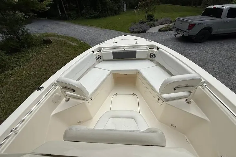 Slide: The Image of 2020 Cobia 240 Center Console boat interior with white seating and speakers. - 23
