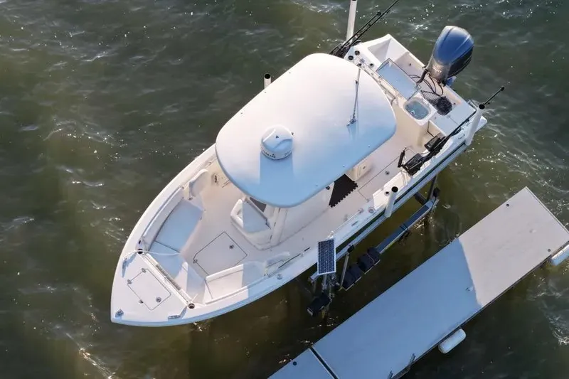 Slide: The Image of 2020 Cobia 240 Center Console boat docked on water. - 6