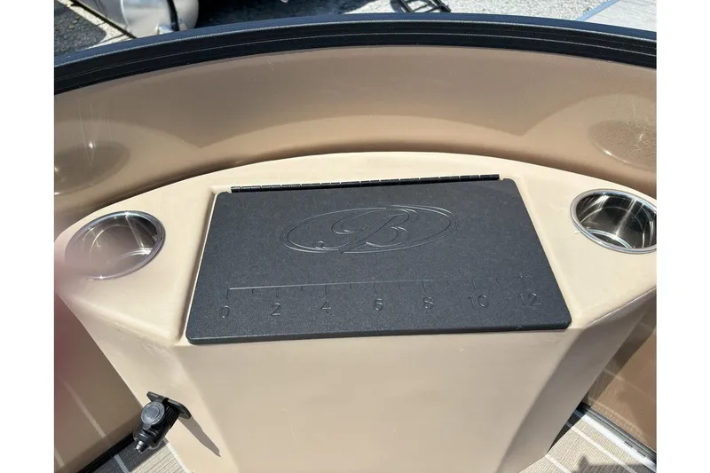 Slide: The Image of The image shows a helm console with two cup holders and a black pad with a measurement scale. - 12