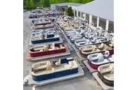Slide: The Image of Several pontoon boats are parked in an outdoor display area. - 27