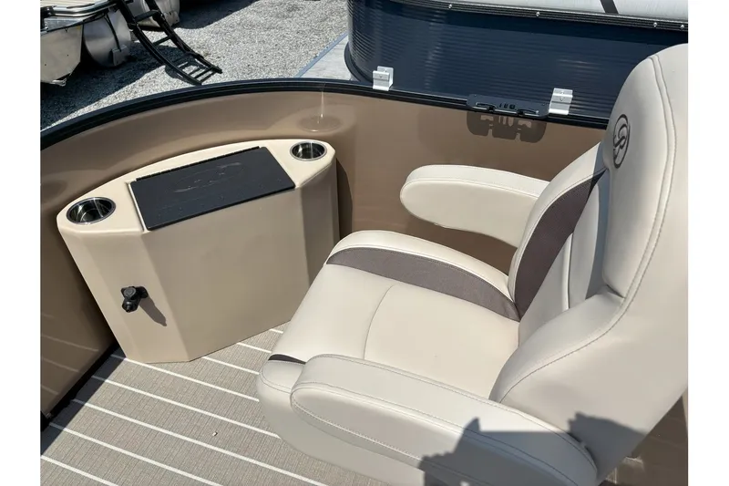 Slide: The Image of Beige seat with armrests on a pontoon boat, next to a small table with cup holders. - 11