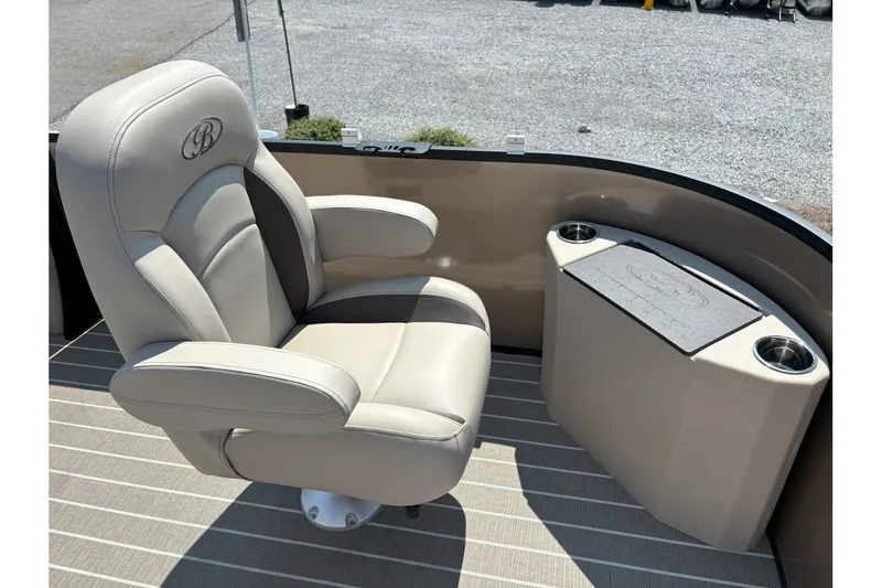 Slide: The Image of A beige captain's chair on a pontoon boat with cup holders and a small table. - 14