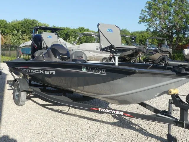 Slide: The Image of A gray Tracker boat, model Pro Team 175 TF, sits on a trailer in a gravel lot. - 4