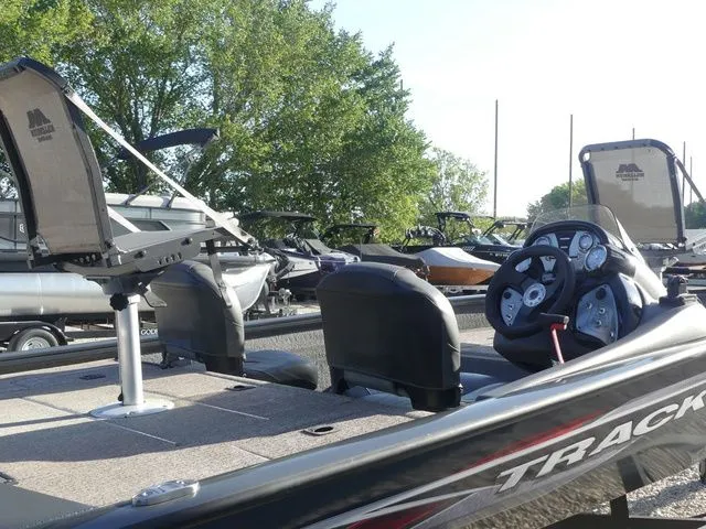Slide: The Image of A 2022 Tracker Pro Team 175 TF with two seats and a console, surrounded by trees. - 24
