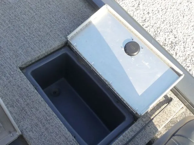 Slide: The Image of An open storage compartment on a boat with gray carpet flooring. - 32