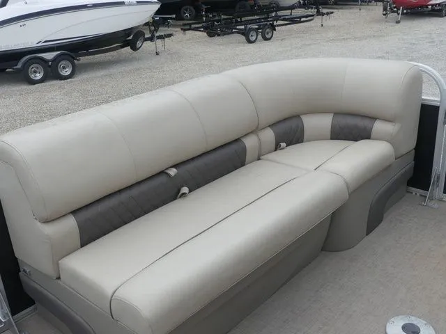 Slide: The Image of Beige seating on a pontoon boat, surrounded by other boats on trailers. - 31