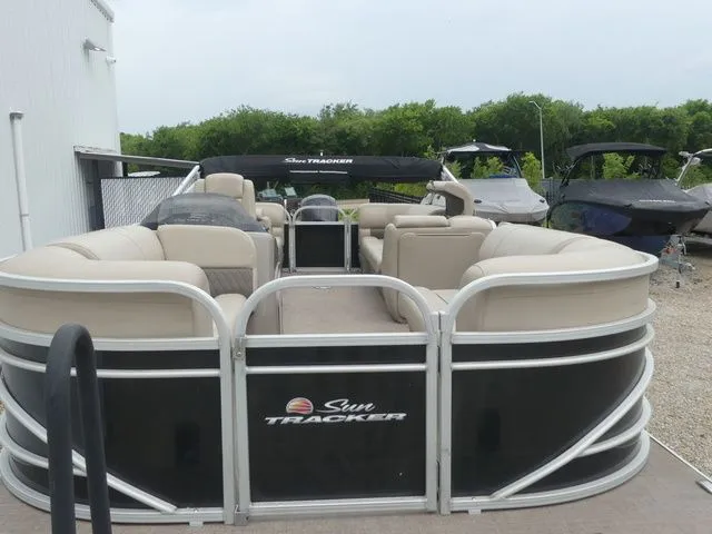 Slide: The Image of A 2020 Sun Tracker Party Barge 22 DLX on a dry dock. It features beige seating. - 19