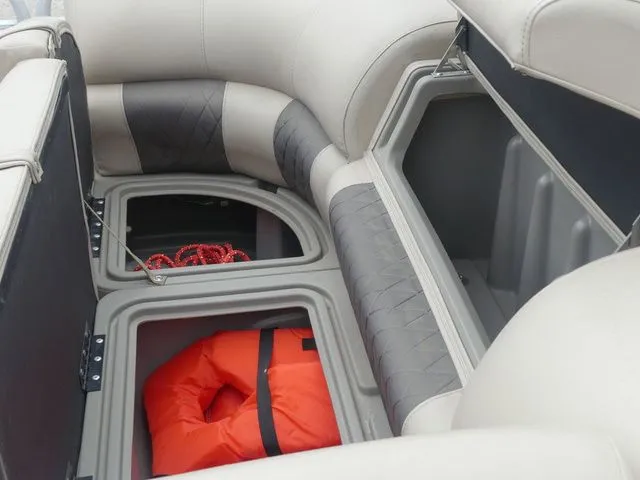 Slide: The Image of The image shows storage compartments of a 2020 Sun Tracker Party Barge 22 DLX with a life jacket. - 35