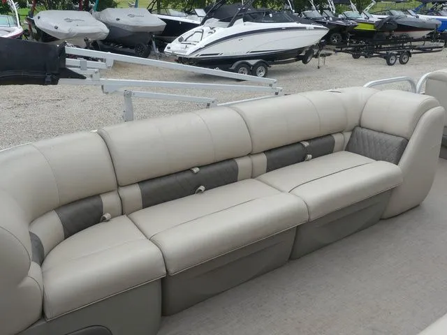Slide: The Image of The image shows a beige and gray seating area on a boat, surrounded by other boats on trailers. - 29