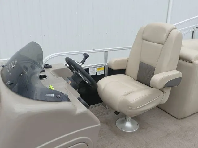 Slide: The Image of The image shows the helm of a 2020 Sun Tracker Party Barge 22 DLX with a beige captain's chair. - 25
