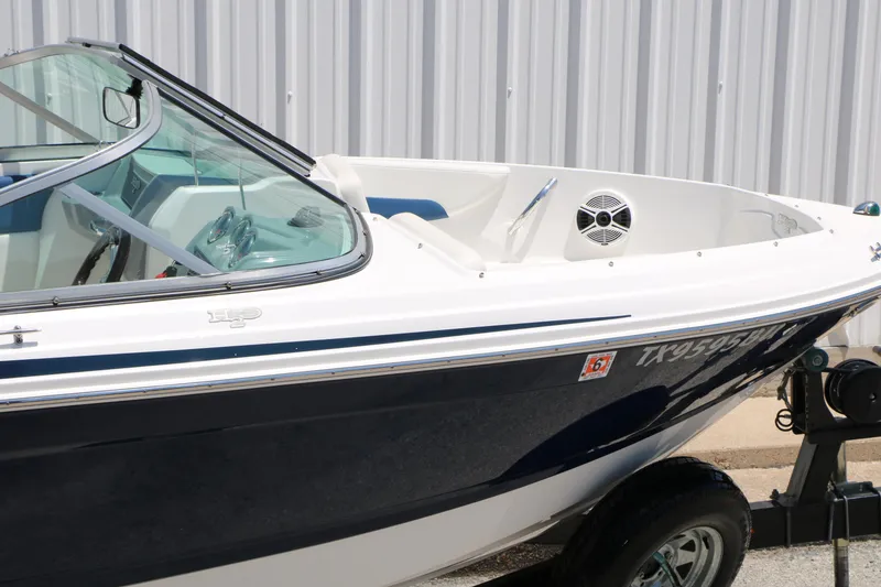 Slide: The Image of 2013 Chaparral 19 Sport H2O boat with sleek design, docked on trailer. - 42