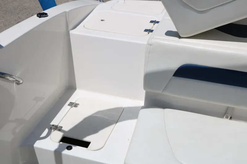 Slide: The Image of 2013 Chaparral 19 Sport H2O boat interior with white seating and storage compartments. - 24